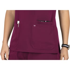 A maroon top featuring two front pockets and an additional pocket, with a logo visible.