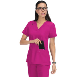 A pink medical top with short sleeves and a pocket, featuring a logo, worn by a woman with glasses.
