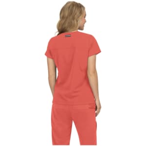 A coral short-sleeve top with a simple design and a logo on the back, paired with matching pants.