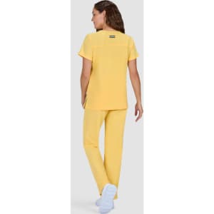 A yellow top and matching pants outfit is displayed from the back, featuring a logo on the top.