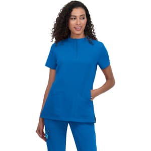 A medical scrub top in bright blue, featuring a neckline zip and two front pockets, worn by a model with curly hair.