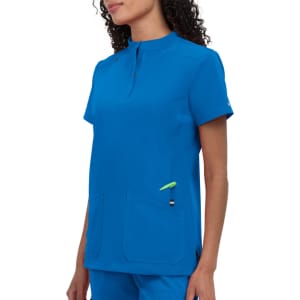 A blue medical scrub top featuring a short collar and two front pockets. The design includes a small accent colour detail.