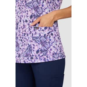 A floral print top in shades of purple featuring butterfly designs and a side pocket, with branding visible.