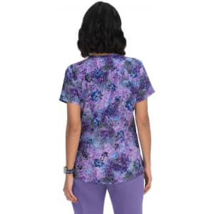 A purple floral print top featuring short sleeves and a back view, with a subtle brand logo.