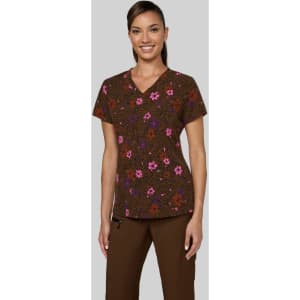 A woman models a brown floral scrubs top with pink and purple flowers, featuring a v-neck design.