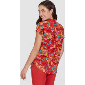 A floral print shirt in red, featuring short sleeves and a button-down back, modelled by a woman.