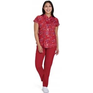 A floral red blouse with short sleeves paired with red trousers, worn by a smiling woman. The outfit has a playful, vibrant design.