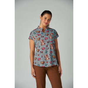 Ari Top (Print) featuring a blue patterned fabric with floral and animal designs, paired with brown pants.