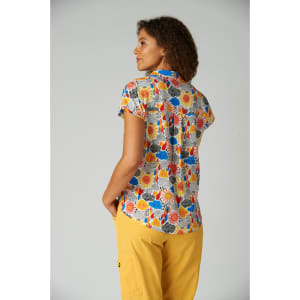 A colourful, short-sleeved top featuring a vibrant print of flowers and shapes, paired with yellow bottoms.