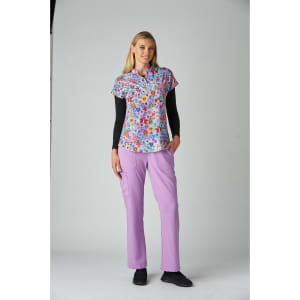 A patterned short-sleeve top in blue with vibrant floral designs, paired with lilac trousers and black shoes.