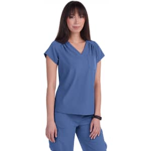 A woman wearing a blue scrubs top with a v-neck and short sleeves, featuring a pocket.