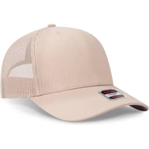 A beige seamless 6 panel mid profile mesh back trucker hat with a logo on the front.