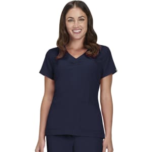 A scrub top in navy blue, featuring short sleeves and a v-neck design, worn by a woman smiling.