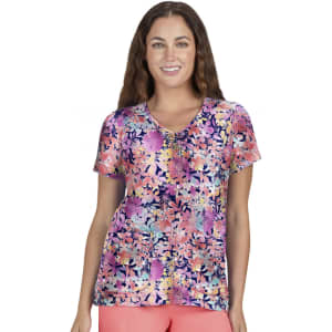 A floral print top featuring vibrant colours such as pink, purple, and white, displayed on a smiling woman.