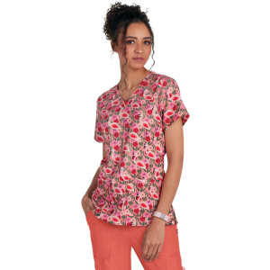 A floral print top in shades of pink and red, featuring a V-neck design and short sleeves. The model wears coral pants.