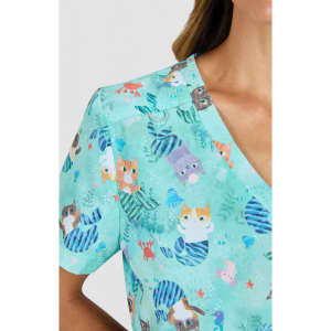 A short-sleeved top in a light teal with a playful animal print featuring cats and marine motifs. It has a branding logo.