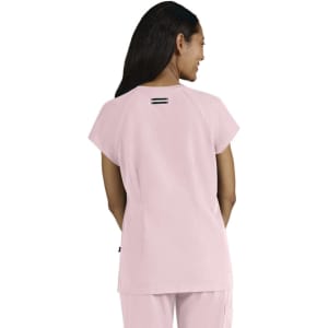A pink women's top with short sleeves and a simple design, featuring a back detail and a logo.