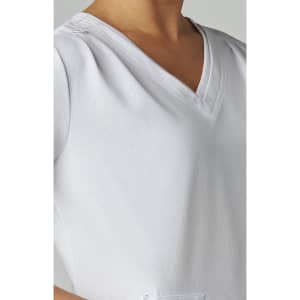 A close-up of a white Sari Top featuring a V-neck design and textured fabric. It has a branding logo.