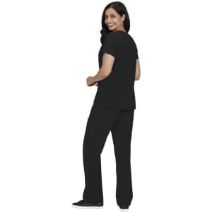 A woman in a black Sari Top and matching pants, smiling and facing slightly away from the camera.