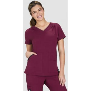 A burgundy Sari Top featuring a V-neck design and two front pockets, worn by a smiling model.