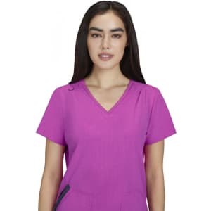 A pink Sari Top featuring a v-neck design and short sleeves, modelled by a woman with long dark hair.