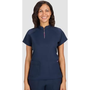 A navy blue women's top with a zip neck and two front pockets. The model is smiling and has wavy hair.