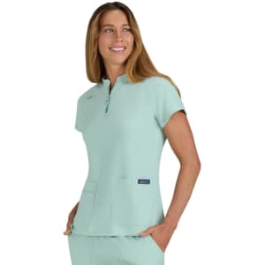 A mint green top with a zip neck and two front pockets, featuring a logo on the side.