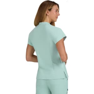 A short-sleeved, mint green top with a fitted design and a back slit, featuring branding details.