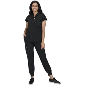 A woman models a black two-piece outfit, featuring a short-sleeve top and tapered pants with pockets.