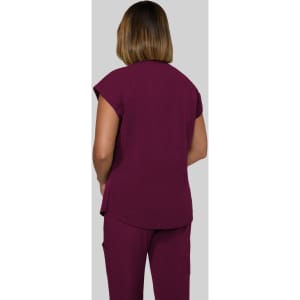 A woman in a maroon top, viewed from the back, wearing matching pants. The outfit has a casual design.