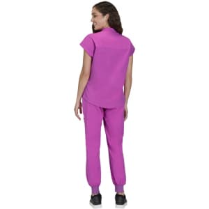 A woman wearing a pink top and pink pants, viewed from the back, standing against a white background.