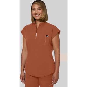 A top in a burnt orange colour with a rounded neckline and short sleeves, featuring a small pocket and a logo.