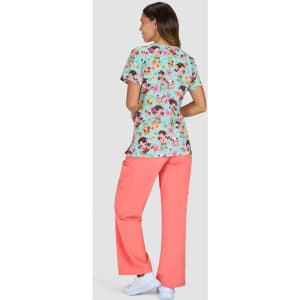 A patterned top in turquoise with floral designs paired with bright coral-coloured pants. The model is facing away.