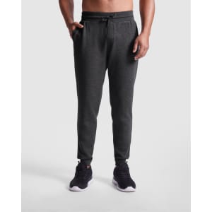 Track pants in dark grey with side pockets and a drawstring waist, featuring a logo on the leg.