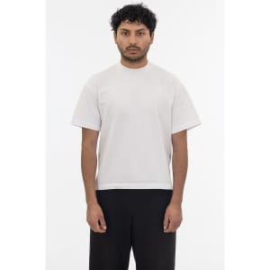A plain white short sleeve garment dye T-shirt displayed on a model, featuring a simple design and relaxed fit.