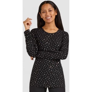 A long-sleeved black tee featuring a polka dot pattern, worn by a smiling person with long hair.
