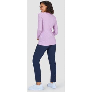 A women's long-sleeve pink top with a pattern, paired with navy-blue trousers and light shoes.