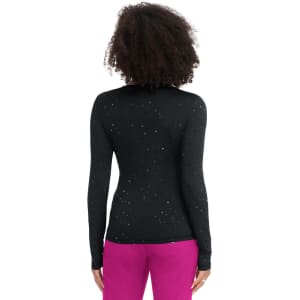 A black long-sleeve tee with a speckled pattern, worn with vibrant pink pants. The back view highlights the textured design.