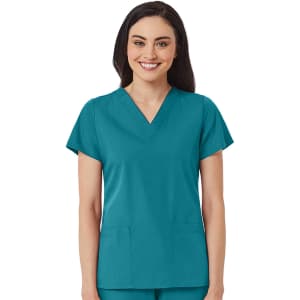 A women's v-neck top in teal, featuring short sleeves and two front pockets. The model is smiling and wearing the top.