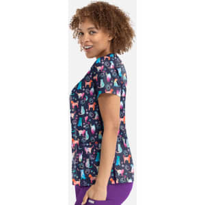 A women's v-neck top featuring a colourful print of various dogs against a dark background. The top has a logo.