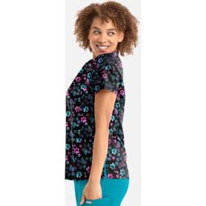 A women's V-neck top featuring a floral print in pink, purple, and blue on a black background. It has a logo on the side.