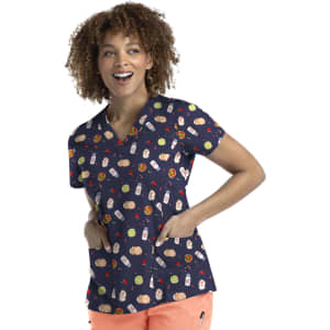 A woman wearing a navy printed curved V-neck top featuring various colourful designs, with pockets on either side.