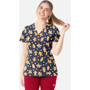 A V-neck print top featuring a navy background with gingerbread man patterns, paired with red pants.