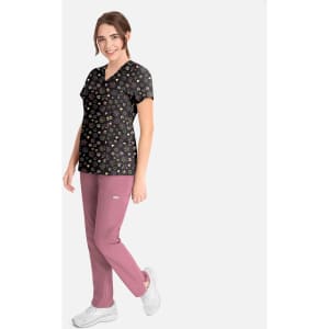 A floral-print women's V-neck top in black, paired with pink pants. The outfit features a logo on the top.