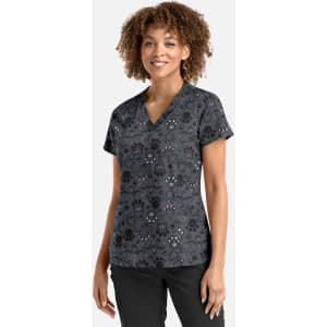 A women's V-neck top featuring a grey fabric with a colourful pattern. It has a logo on the left side.