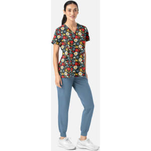 A floral V-neck top in multicolours paired with blue pants, featuring a logo on the shirt.
