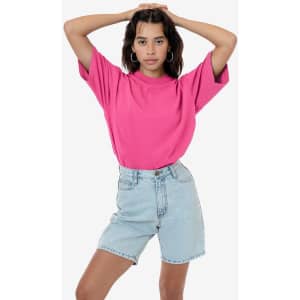 A pink short sleeve crewneck t-shirt paired with light denim shorts. The model poses with arms raised.