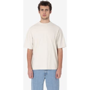 A short sleeve crewneck tee in a light beige colour, featuring a relaxed fit and a logo.