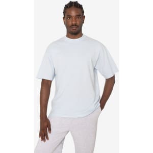 A light blue short sleeve crewneck tee with a relaxed fit, featuring a logo on the side.