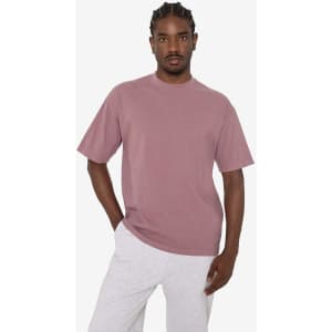 A short sleeve crewneck tee in a muted pink colour, featuring a relaxed fit and a logo.